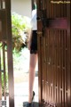 A woman standing in front of a wooden door.