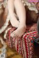 A woman sitting on top of a bed with her feet up.