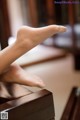 A woman's bare feet sitting on a piano.