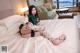 A woman sitting on top of a bed in a hotel room.