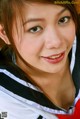 A young woman in a black and white jacket posing for a picture.