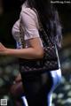 A woman carrying a black chanel bag on a runway.