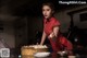 A woman in a red dress preparing food in a kitchen.