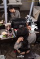 A woman sitting in front of a mirror in a bathroom.