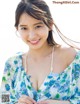 A woman in a blue and white floral dress posing for a picture.