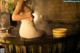 A woman sitting in a wooden bathtub with steam coming out of it.