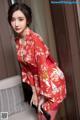 A woman in a red kimono posing for a picture.