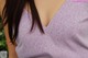 A close up of a woman wearing a purple top.