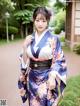 A woman in a blue and white kimono posing for a picture.