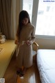 A woman standing in front of a window in a hotel room.