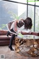 A woman in a maid outfit cleaning a coffee table.