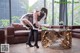 A woman in a maid outfit is bending over a coffee table.