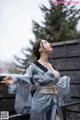 A woman in a blue kimono standing in the snow.