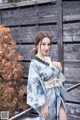 A woman in a blue and white kimono posing for a picture.