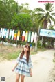 A woman standing in front of a row of surfboards.