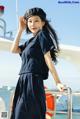 A woman in a sailor outfit standing on a boat.