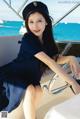 A woman sitting on the steering wheel of a boat.