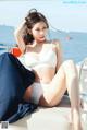 A woman in a white bikini sitting on a boat.