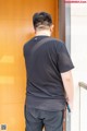 A man standing in front of a wooden door.