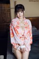 A woman in a pink kimono is tied up with a rope.