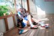 A woman in a blue and white outfit sitting on a wooden floor.