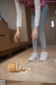 A woman standing on the floor next to a cup of coffee.