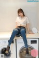 a woman sitting on top of a washing machine