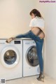 A woman sitting on top of a washing machine.