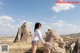 A woman standing on top of a large rock formation.