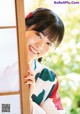 A woman in a kimono leaning against a window.