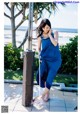 A woman in a blue dress standing next to a water fountain.