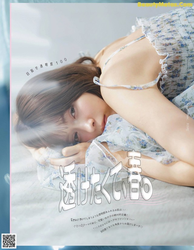 A woman laying on top of a bed in a blue dress.