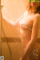 A woman in a white bikini taking a shower.