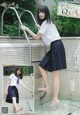 A woman in a school uniform is posing by a pool.