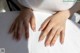 A woman's hands on a white table.