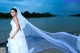 A woman in a wedding dress standing on a dock.