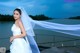 A woman in a wedding dress standing on a dock.