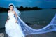 A woman in a wedding dress standing on a dock.