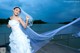 A woman in a wedding dress standing on a dock.